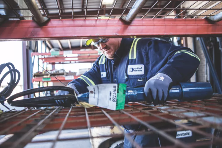 trabajador que retira una herramienta de un estante
