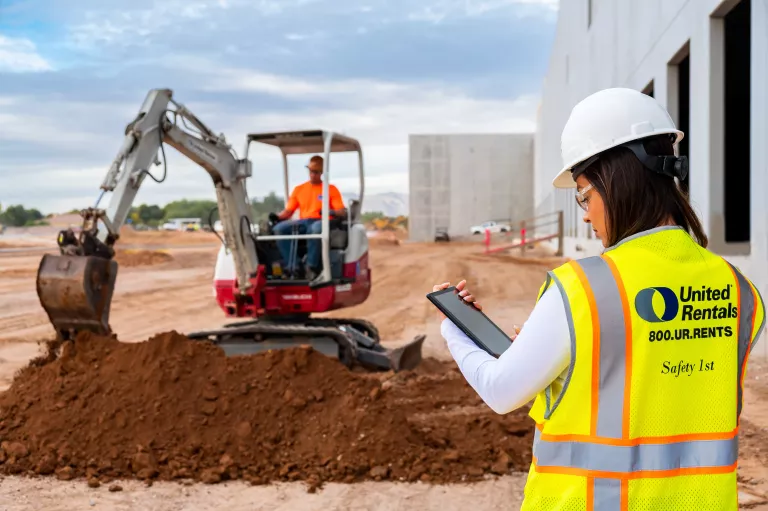Excavadora y tableta en sitio de trabajo