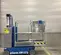 Side view of a blue Genie one-person lift with safety rail, in an indoor work zone.