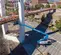 Wide side view of a blue Genie telescopic boom lift in use on a construction site, operator working at height on bridge.