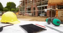 tablet and hard hat on construction site outside