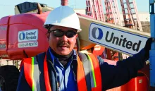 man in construction ppe next to boom lift