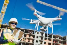 female drone pilot operating uav on construction site
