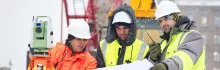 trabajadores con chalecos de seguridad y cascos en un sitio de construcción en invierno