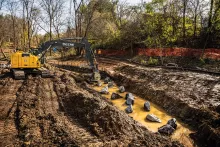 Excavadora John Deere amarilla excavando tierra