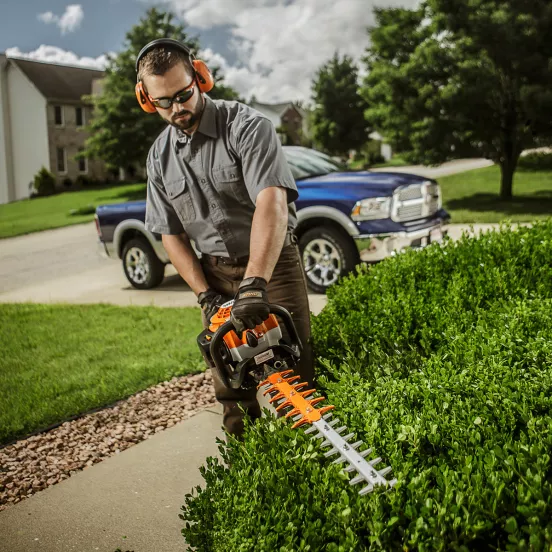 Podador de setos con cuchilla de 30 pulgadas Stihl naranja que se utiliza para cortar setos